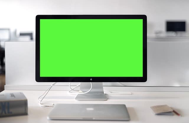green monitor screen and apple macbook